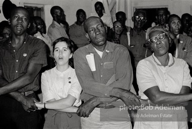 Joining the flock, West Feliciana Parish, Louisiana. 1963

“In West Feliciana, an overwhelmingly black parish where no person of color had voted in the twentieth century, volunteer Mimi Feingold urged members of a church congregation to try to vote. She then joined hands with them to sing, ‘This Little Light of Mine.