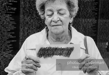 Woman displays rubbing from the Vietnam Wall Memorial. Memorial Day, Washington,1985.