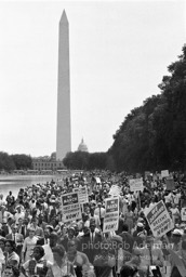 Marching along side the reflecting pool, protestors en route to the Lincoln Memorial with the Washington Monument and Capital Dome in the backround. Washington, D.C. August 28, 1963.