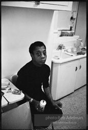 James Baldwin in the kitchen of his NYC apartment. 1964.