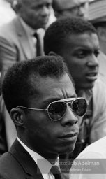 James Baldwin, sitting next to heroic Freedom Rider Jerome Smith, listens attentively to speakers at the ceremony in front of the Lincoln Memorial.  March on Washington. 1963.