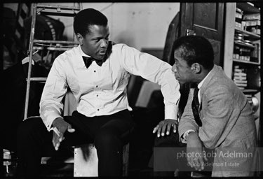While writing a story for LOOK magazine, writer James Baldwin talks with Sidney Poitier on the set of  the film 'For Love of Ivy', 1968.