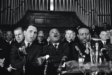 King leads the singing of ÒWe Shall OvercomeÓ after eulogizing a slain civil rights crusader, the Reverend James Reeb, Brown Chapel,  Selma,  Alabama.  1965