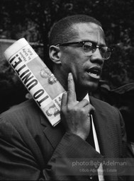 Malcolm X at a civil rights demonstration, Brooklyn, New York City.  1963-


“He was a fiery orator. No one could give tongue to the grievous wrongs suffered by African Americans in white America more trenchantly
than Malcolm. To get his message out to the assembled press, he
showed up at civil rights demonstrations as the photographer for The Messenger. We sometimes
discussed cameras and f- stops. I was surprised when he asked me how I thought the Black Muslim faith compared to Islam.
Emphasizing my limited knowledge, I very hesitantly favored Islam — it welcomed all races and was older and wiser. Some
time later he converted to Islam, which was a great revelation for him but, tragically, led to his assassination.”