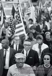 “King broke into a grin as he entered the city limits of Montgomery. Some of the obstacles he had overcome had to be on his mind.”


The marchers unfurl their flags, preparing to parade through the city,  Montgomery,  Alabama.  1965