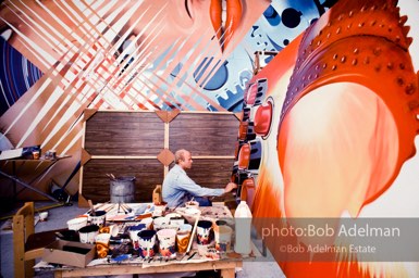 James Rosenquist working on “Fahrenheit 1982” with “Four New Clear Women” mural in background. Chambers Street studio, 1982.