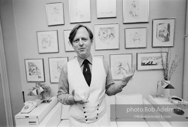 1975- Tom Wolfe in his New York City apartment on the Upper East Side in front of a wall of his drawings.